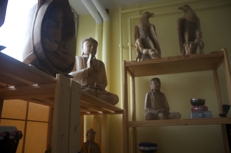 Buddha-Holzschnitzereien und Adler-Statuen im Praxisraum des Shingon Reiki Instituts